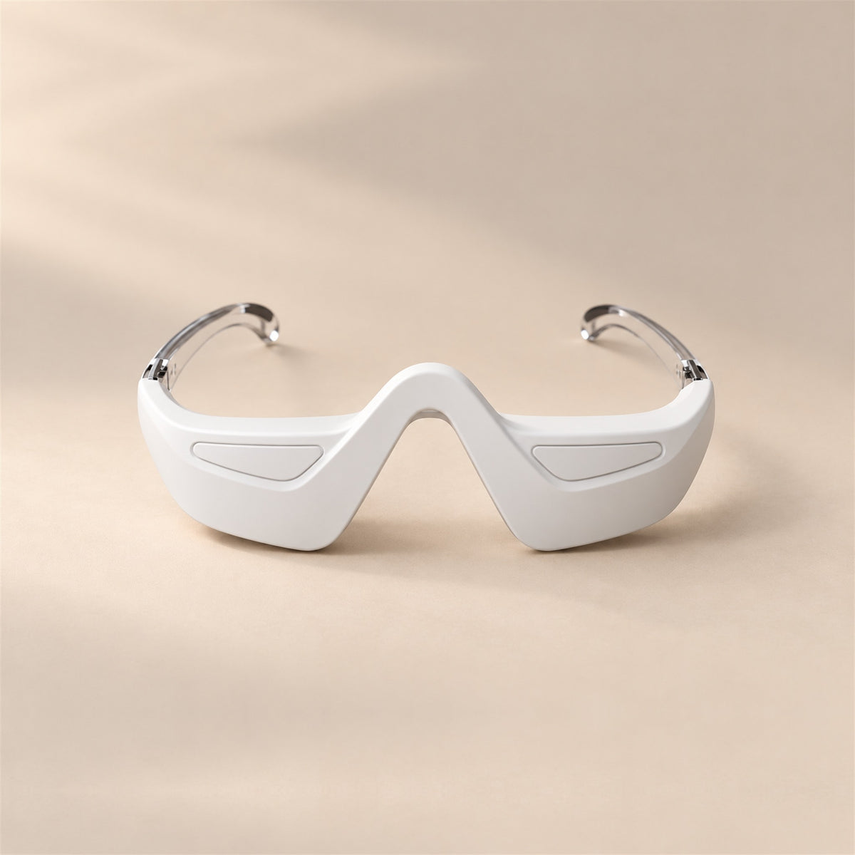 bewhile halo from the front on a sand background: a white under-eye band with a nose bridge and clear temple arms (mockup)